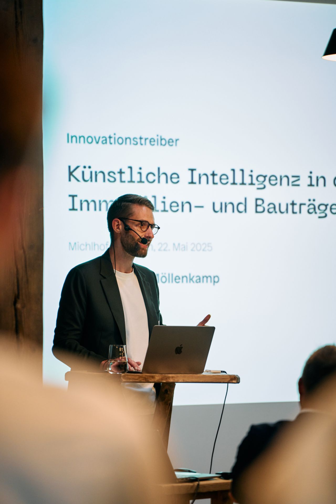 Nilas Möllenkamp hält einen KI-Vortrag vor einer Leinwand
